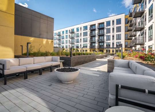 Outdoor seating area with couches and firepit in the courtyard at Aspire at CityPlace Woodbury