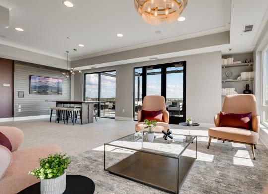 Community space with several seating areas and a walk out to an outdoor patio