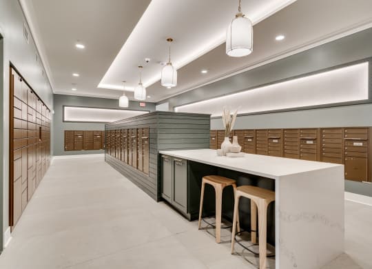 Mailroom lined with package lockers and mailboxes and island seating in the middle