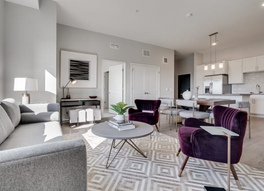 Furnished living room with high ceilings looking into the kitchen at Aspire at CityPlace Woodbury MN 55125