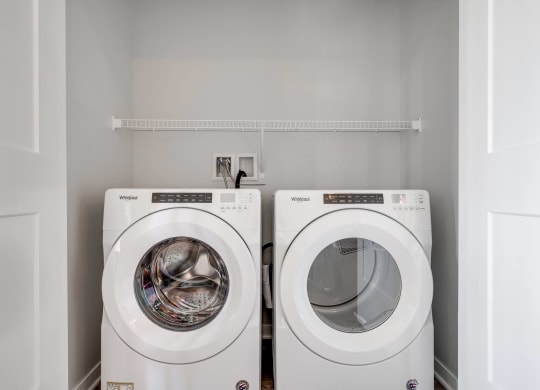 Side by side front loader washer and dryer in a laundry closet in two bedroom luxury apartment Woodbury MN 55125