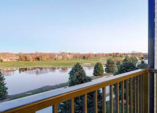 a view from a balcony overlooking a pond and the Wilderness Ridge Golf Course