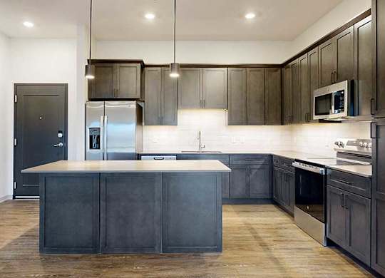 a modern kitchen with dark wood cabinets and stainless steel appliances