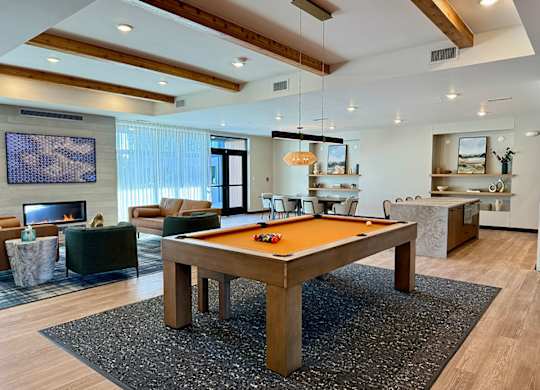 A pool table in the middle of a room with a fireplace and a TV
