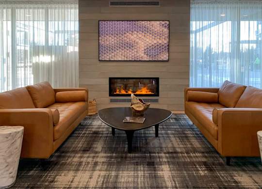 a fire place and seating area in the clubroom of Brynwood at Wilderness Ridge in Lincoln, NE 68512