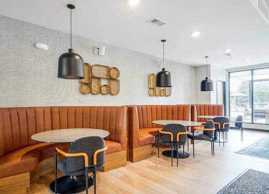 A clubroom with a modern seating area with half-circle leather booths, perfect for working or study spaces.