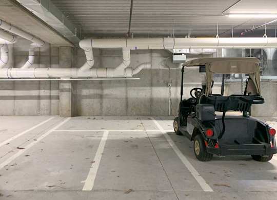 a golf cart parked in a dedicated space in the underground climate-controlled garage