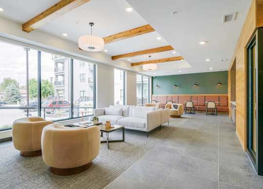 a modern, cafe-style lounge with armchairs, couches, tables and chair, and a coffee bar