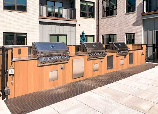 a row of stainless steel gas grilling stations with built in counterspace