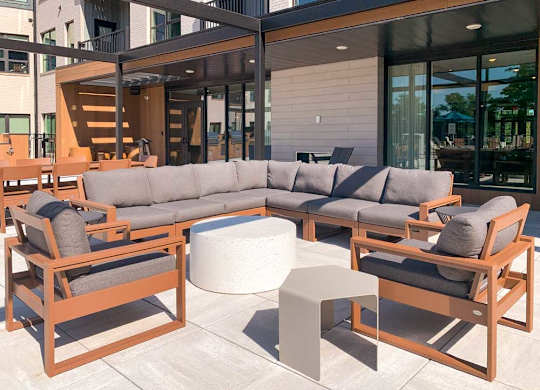 a social seating area with a sectional and chairs surrounding a table