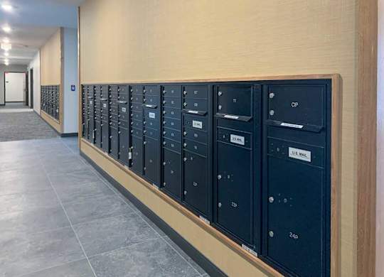 a row of black mailboxes are lined up on a wall next to the fitness center