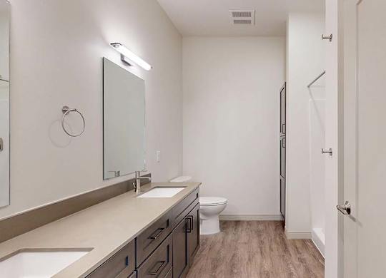 A bathroom with a toilet, sink, and mirror.