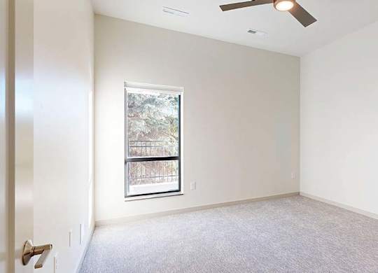 A room with a window and a ceiling fan.