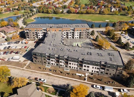 an aerial view of a building next to a lake