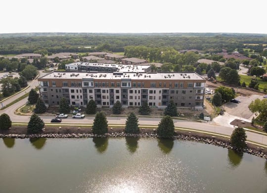 an aerial view of a building next to a lake