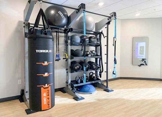 a yoga and spin studio in a fitness center, with a punching bag, yoga equipment, and on demand fitness classes