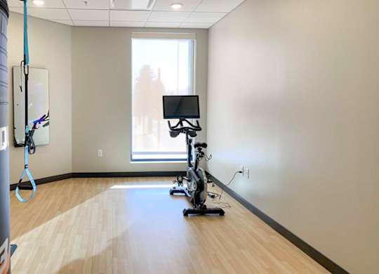 a  yoga and spin studio with an exercise bike in front of a window and interactive fitness mirror