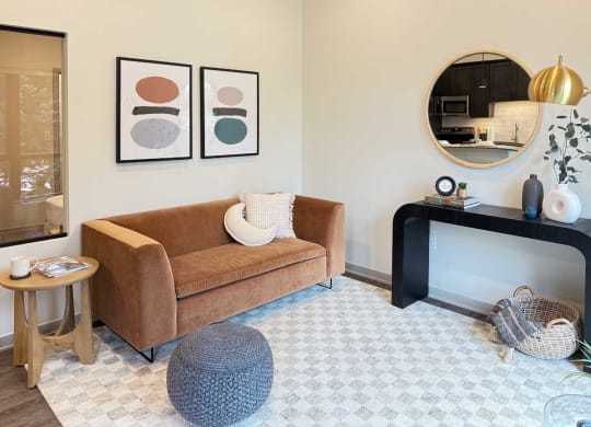 a cozy living room with a modern velvet couch and other contemporary furniture in the guest suite, available for resident use
