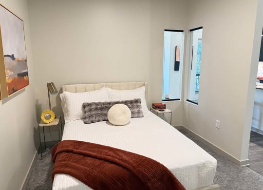 a sleeping area with a privacy wall featuring two windows