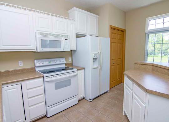 a kitchen with white appliances and white cabinets