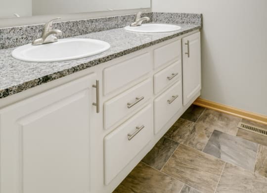 bathroom with dual sinks and white cabinetry at Cascade Pines Duplex and townhomes