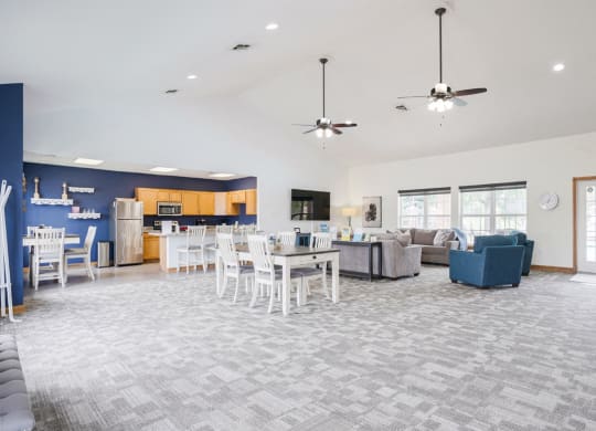 Wide view of the clubhouse at Williamsburg Park with dining table, TV lounge, and community kitchen in the back