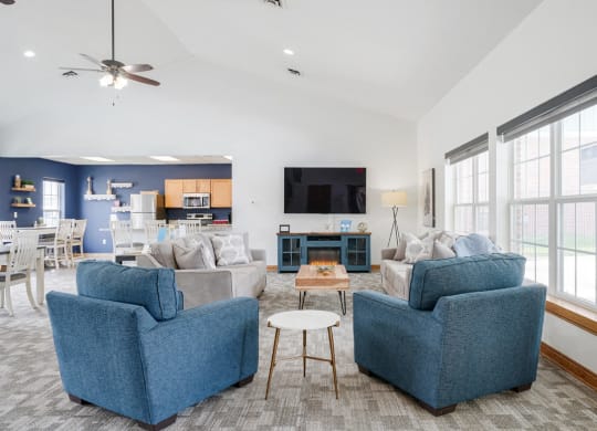 Lounging area with TV on the wall and couches and chairs