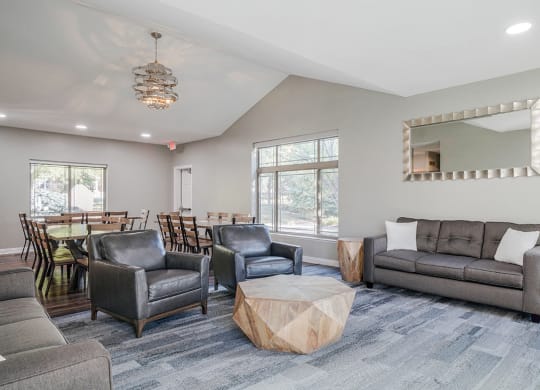 a seating area with chairs and couches next to a dining area