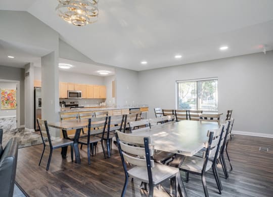 a clubhouse dining room with several tables next to a kitchen