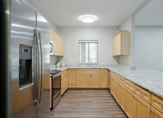 a kitchen with wooden cabinets and granite counter tops in the clubhouse
