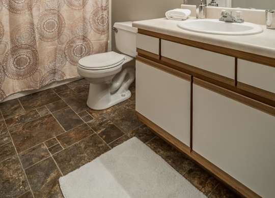 A bathroom with a toilet, sink, and shower curtain.