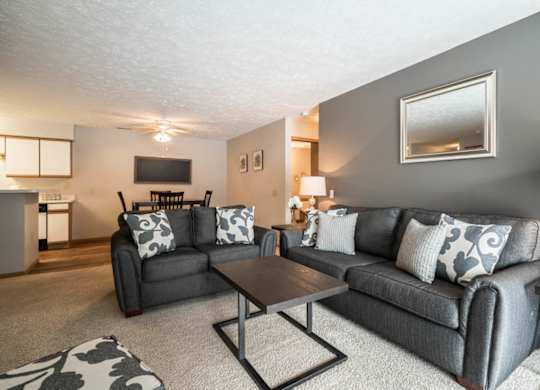 A living room with grey couches and a coffee table.