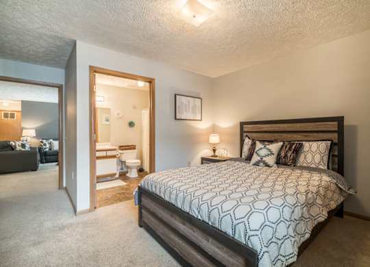 A bedroom with a large bed and attached bathroom