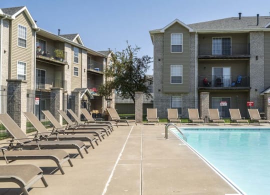 Outdoor swimming pool with lounge chairs at Eagle Run Apartments in northwest Omaha 68164