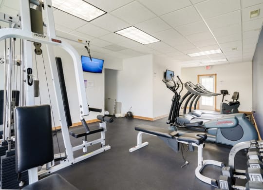 24-hour fitness center with exercise equipment and a tv