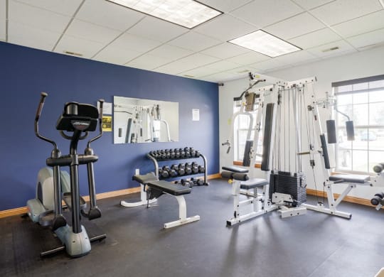 24-hour fitness center with an elliptical, dumbbell weights, and cable machine