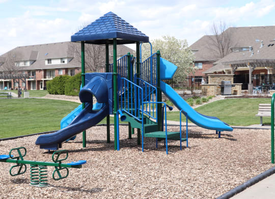 Children's playground with slides and a seesaw at Fountain Glen Apartments in Lincoln, NE
