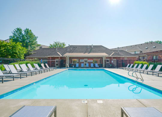 the swimming pool surrounded by rows of lounge chairs behind the clubhouse