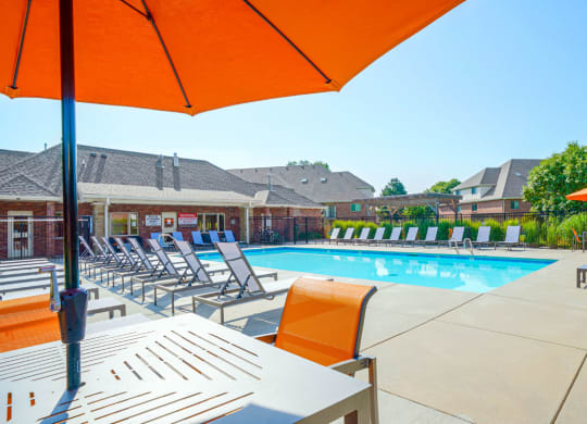 a swimming pool surrounded by rows of lounge chairs and tables with umbrellas and chairs