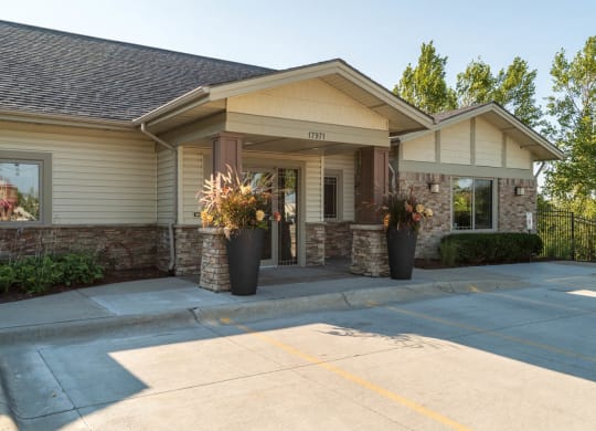 the front entrance of a house with a driveway and a porch