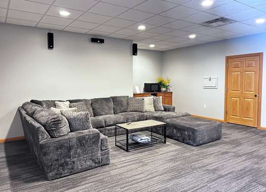a theater room with a grey couch, and a microwave for snacks