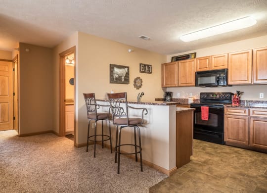 a kitchen with a bar with two stools