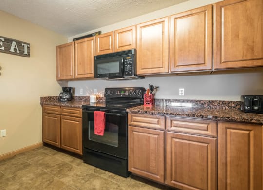a kitchen with black appliances and wooden cabinets