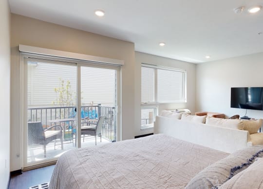 a studio home with a large bed and a tv on the wall