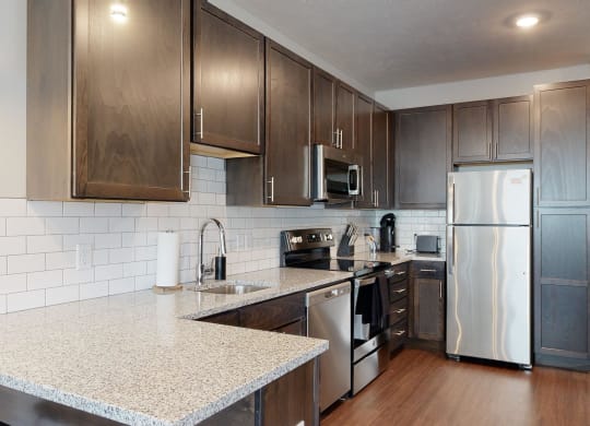 a kitchen with dark wood cabinets and white granite countertops