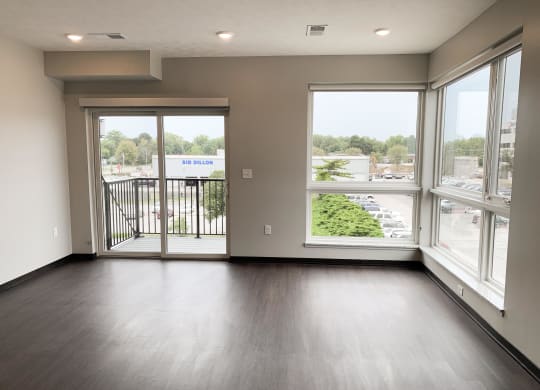 Living room view through corner floor to ceiling windows and sliding door that look out onto north Lincoln, Nebraska