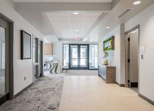 a long hallway with glass doors and a reception desk