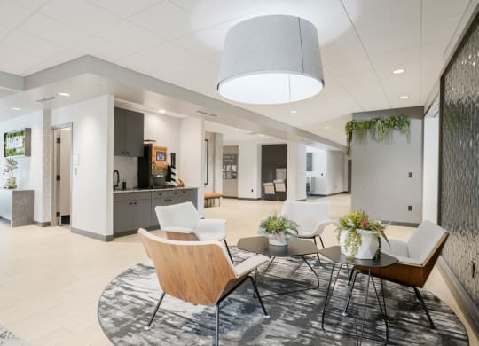 a main lobby area with chairs and a table and coffee bar