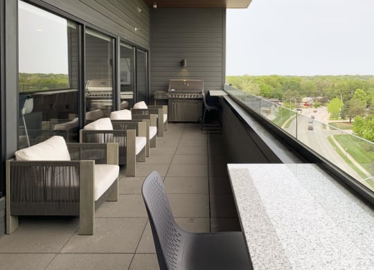 the sky deck with a grill and chairs over looking the city of lincoln