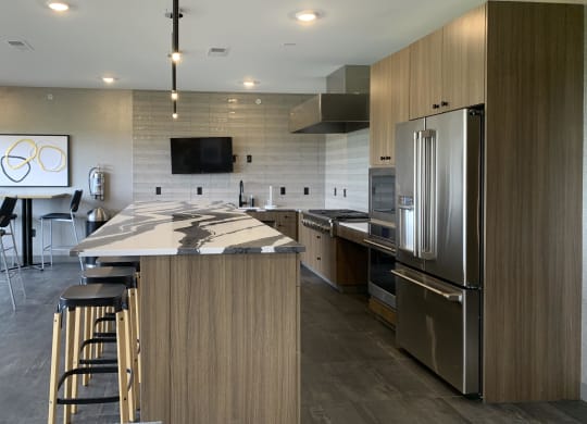 a kitchen in the sky lounge with a large island and stainless steel appliances